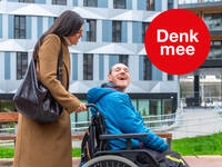 klik en vergroot: Vrouw wandelt met een man in rolstoel en lachen naar elkaar