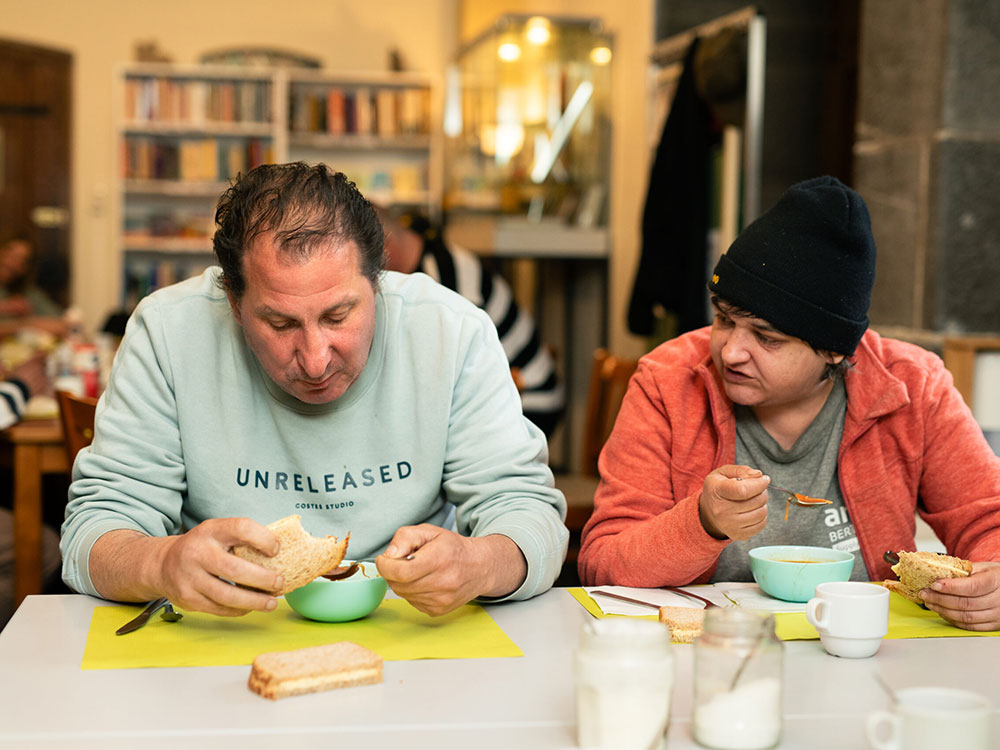 Man en vrouw zitten te eten in de opvang