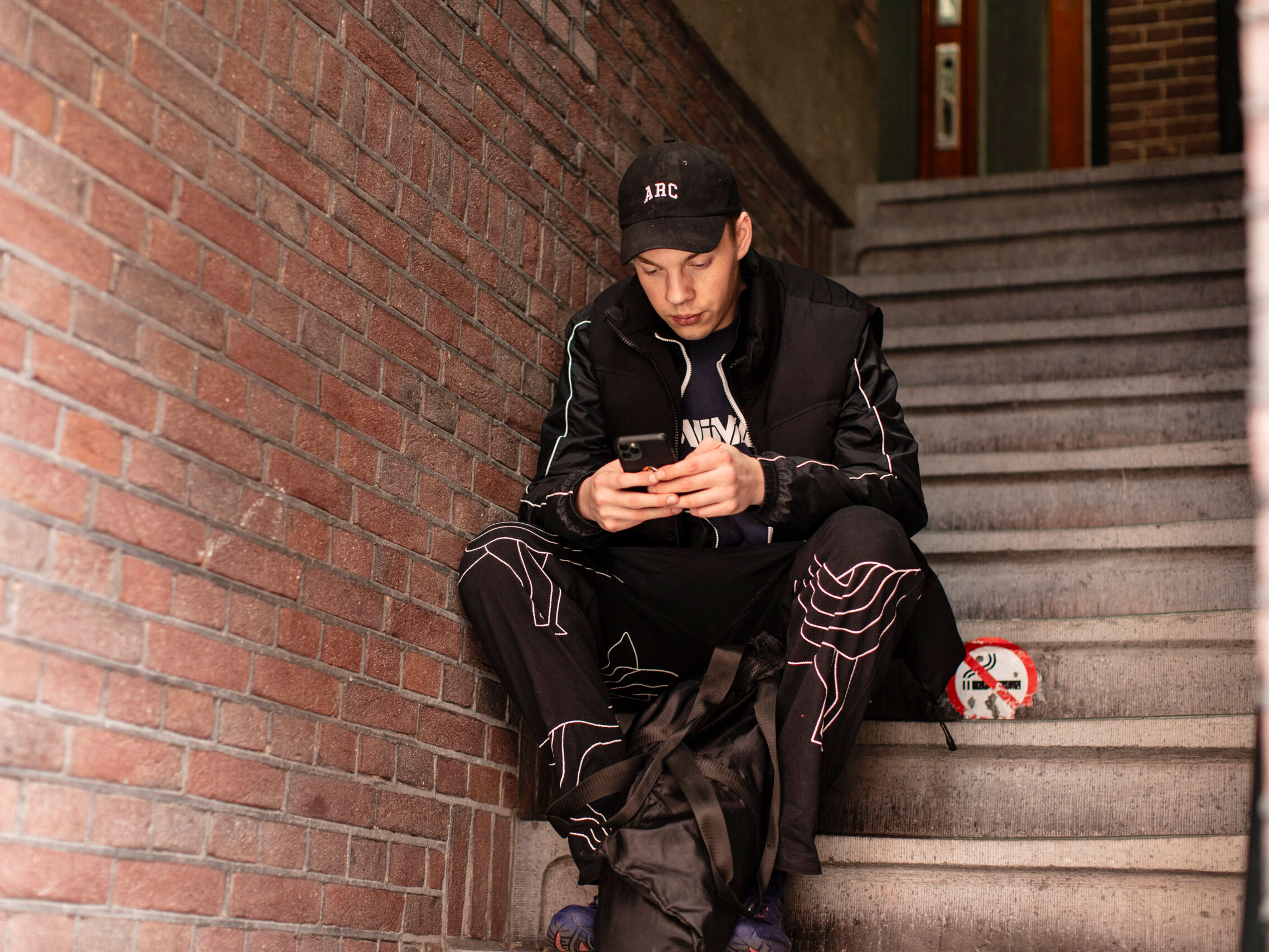 Man zit in een portiek met een tas