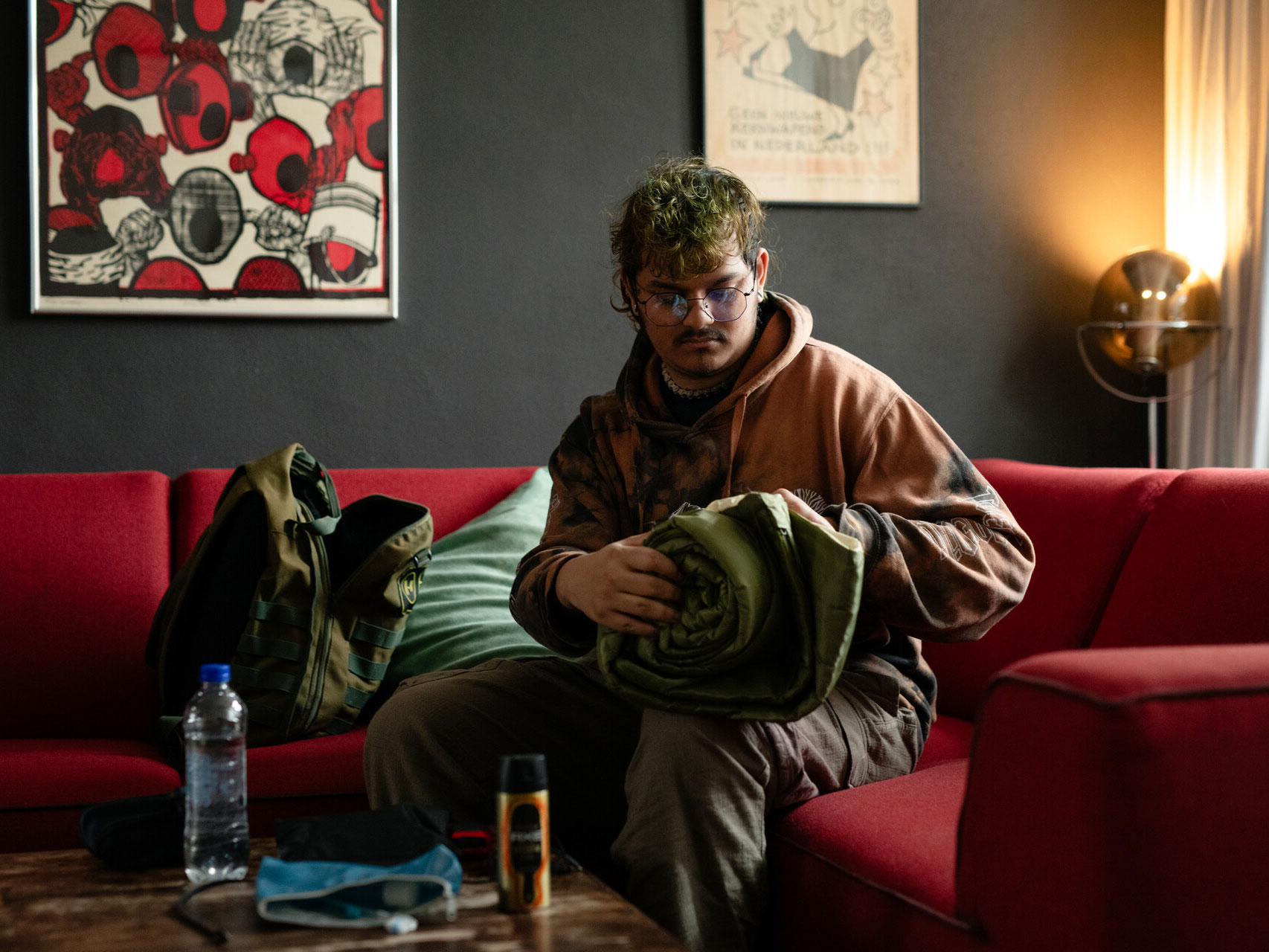 Man zit op bank in huis met deken en toiletspullen